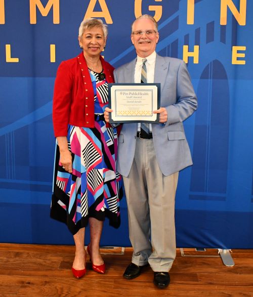 Arndt and Lichtveld with certificate in front of Reimagine Public Health backdrop