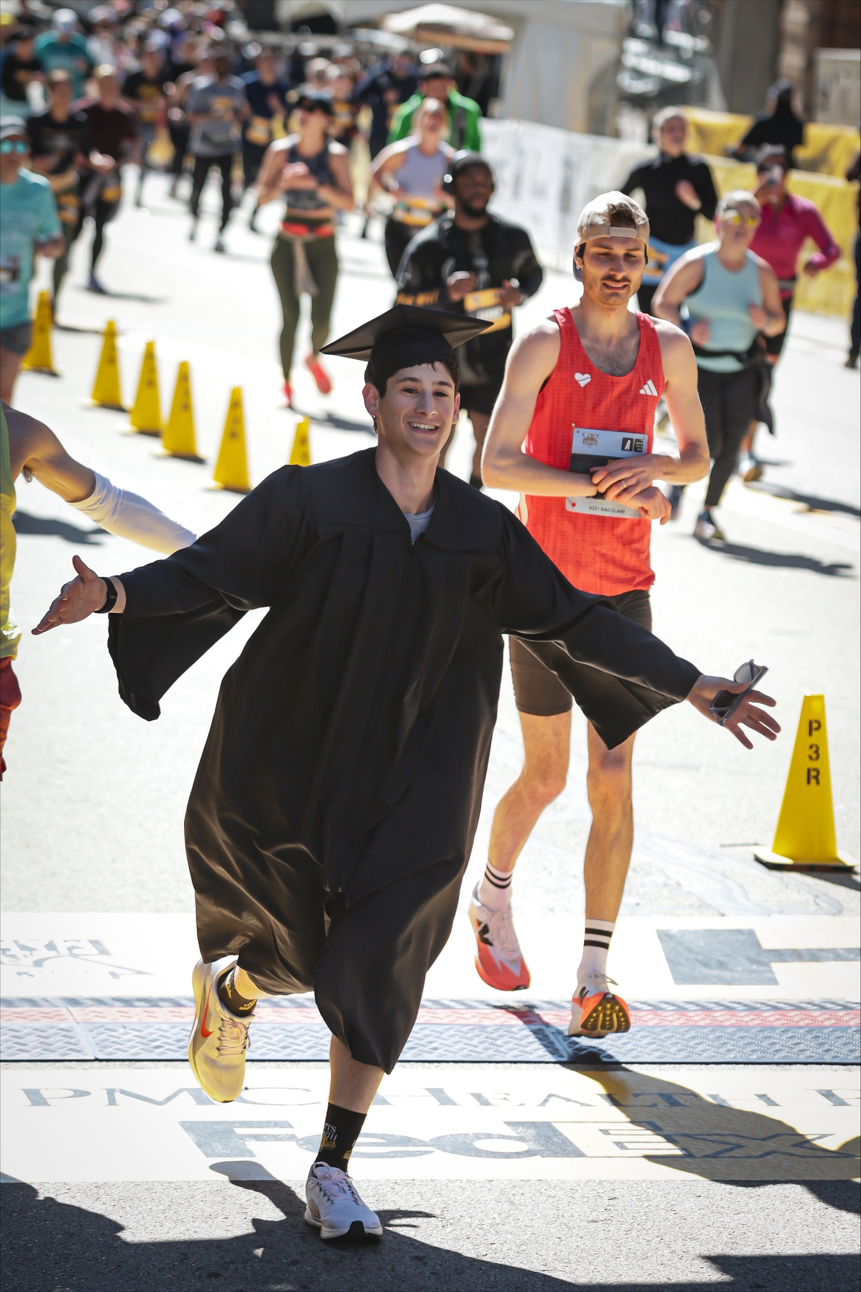 Graduate Sammy Cohen running in his cap & gown,