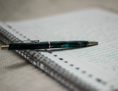 notebook with handwriting and pen
