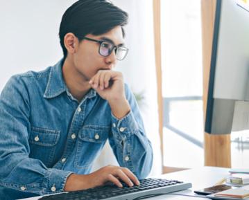 Student sitting at desk typing on keyboard