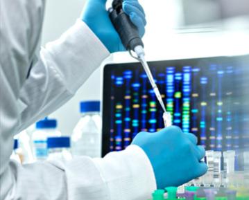 Person in lab coat and gloves working with test tube