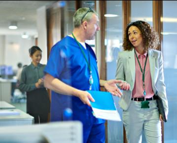 Person wearing scrubs talking to administrator