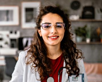 Woman wearing white lab coat and glasses