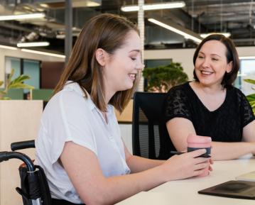 Two people at table together smiling