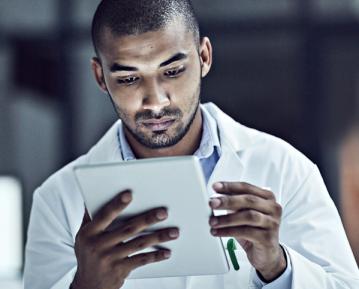 Student in white coat looking at iPad