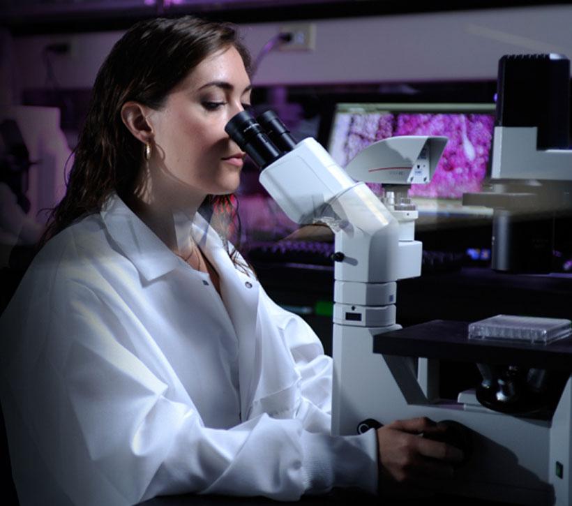 Woman looking into microscope