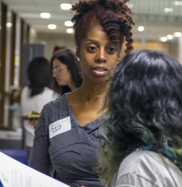 student and community partner discussing possible internships at annual event