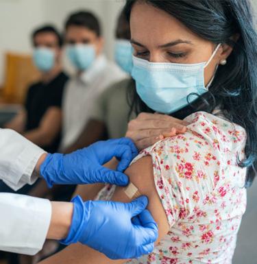 Person wearing mask getting bandaid