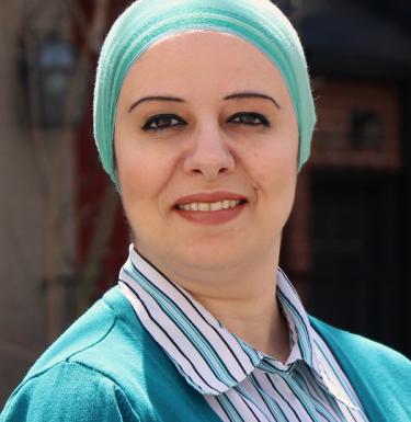 Headshot of a woman wearing blue sweater and blue headscarf