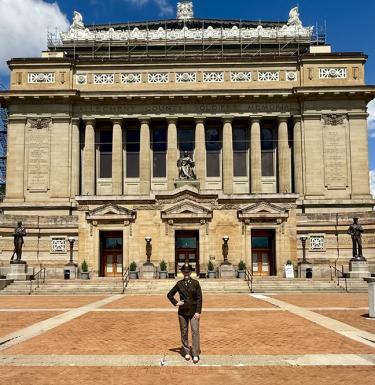 person posing in front of a building