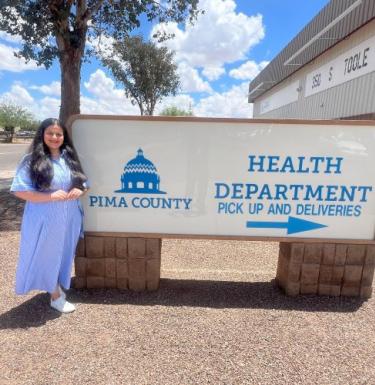 Zaveri on site, outside with the large health department sign