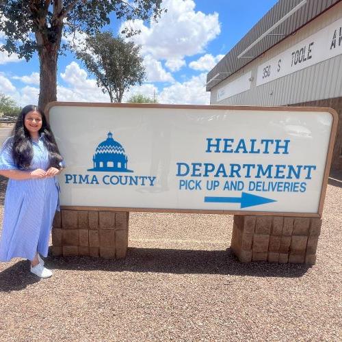 Zaveri on site, outside with the large health department sign